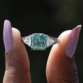 Two fingers holding the Radiant Cut Moissanite Accent Stone Ring