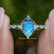 Front view of Blue Turquoise Pear Gemstone Accent Set Ring in two fingers 