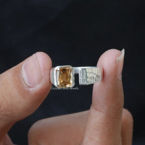 Two fingers holding the Criss Cut Moissanite Toi Et Moi Ring