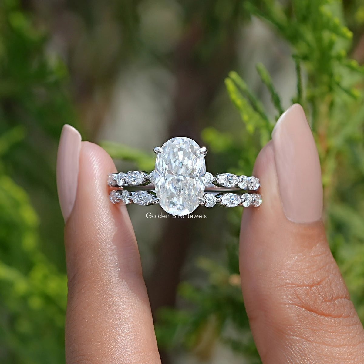 Front view of Crushed ice Oval Cut moissanite Bridal Set ring in two fingers 