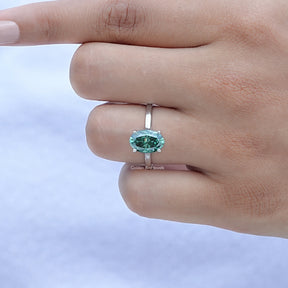 Close-Up View Of Oval Cut Moissanite Solitare Engagement Ring in a finger