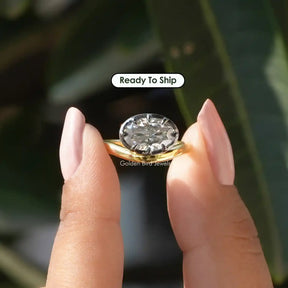 [In two finger front view of oval cut moissanite solitaire ring made of yellow gold]-[Golden Bird Jewels]