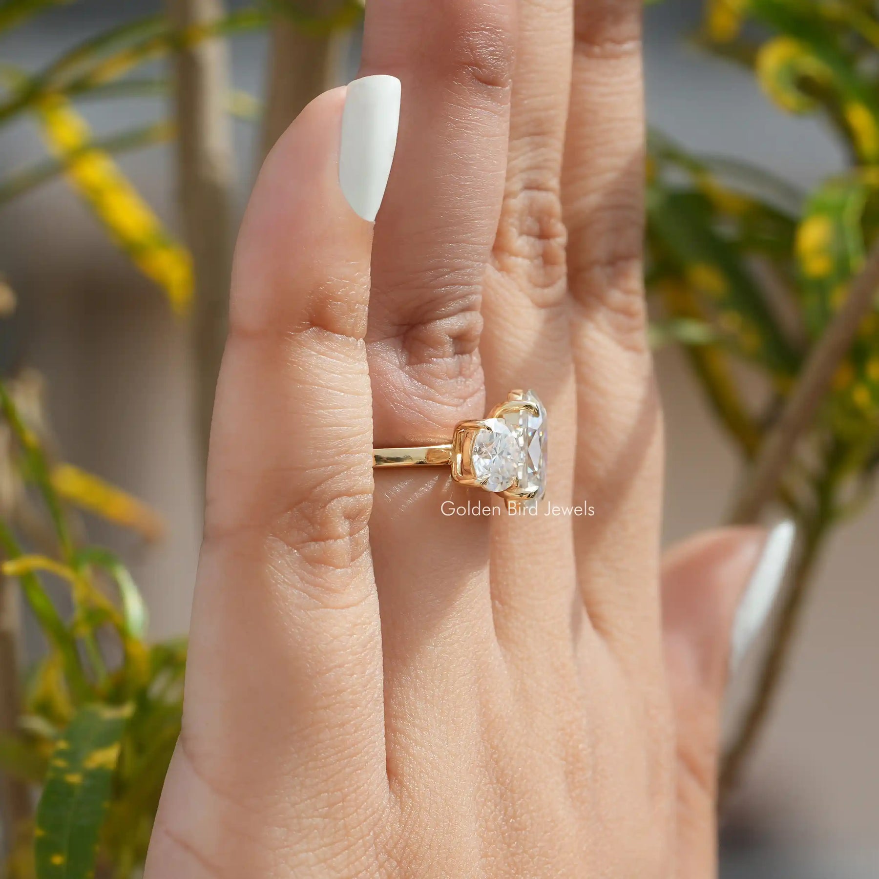 [In finger side view of round and oval cut moissanite ring]-[Golden Bird Jewels]