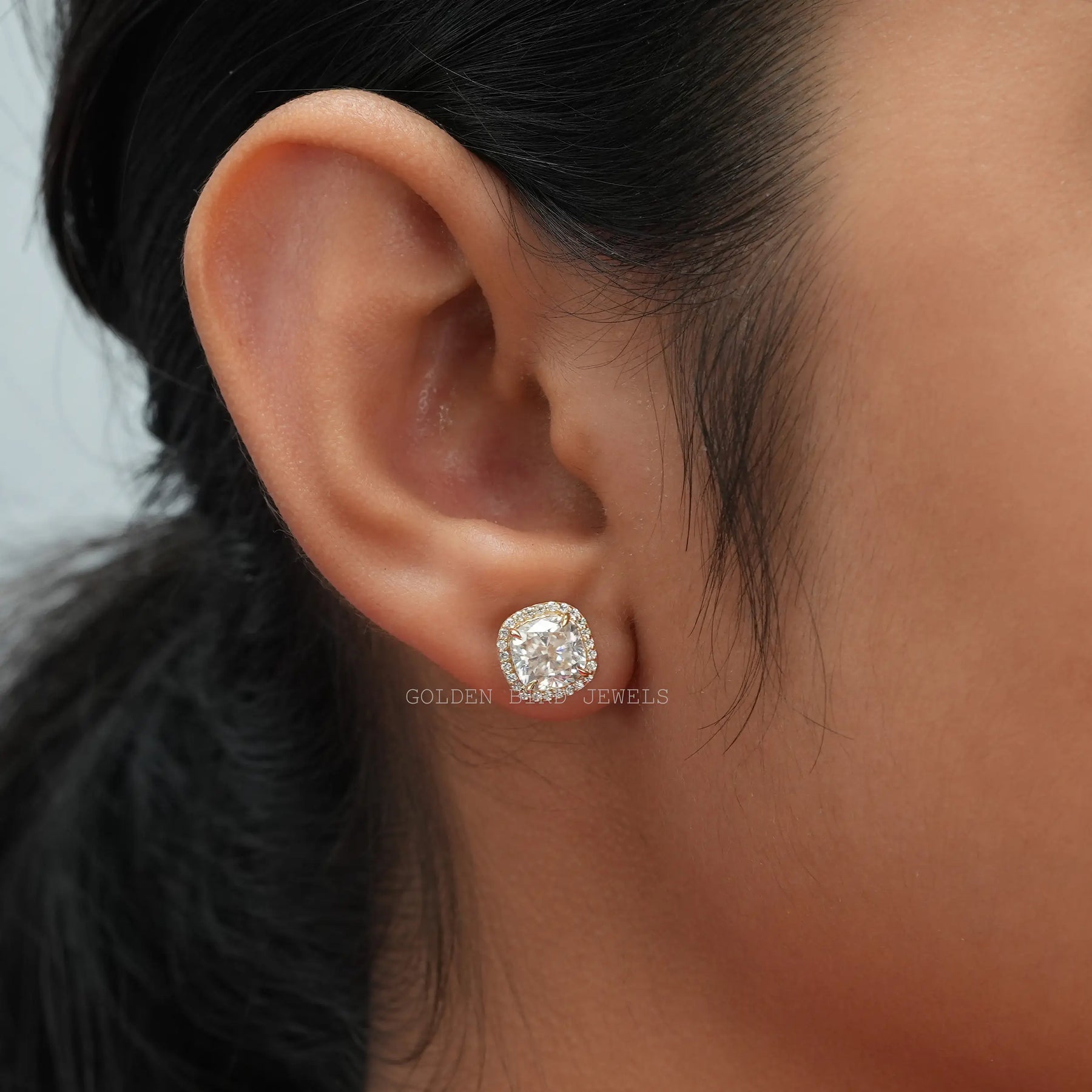 [In ear front view of cushion cut halo stud earrings made of round cut side stones]-[Golden Bird Jewels]