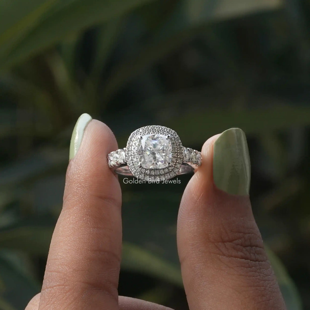 Two fingers holding the Cushion Cut Moissanite Double Halo Moissanite Ring