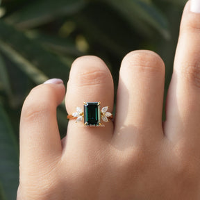 [In finger front view of dark green emerald cut moissanite engagement ring]-[Golden Bird Jewels]