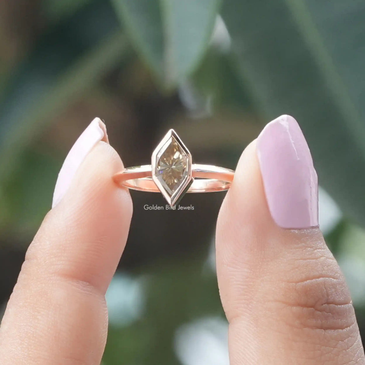 Two fingers holding the Dutch Marquise Cut Solitaire Moissanite Ring