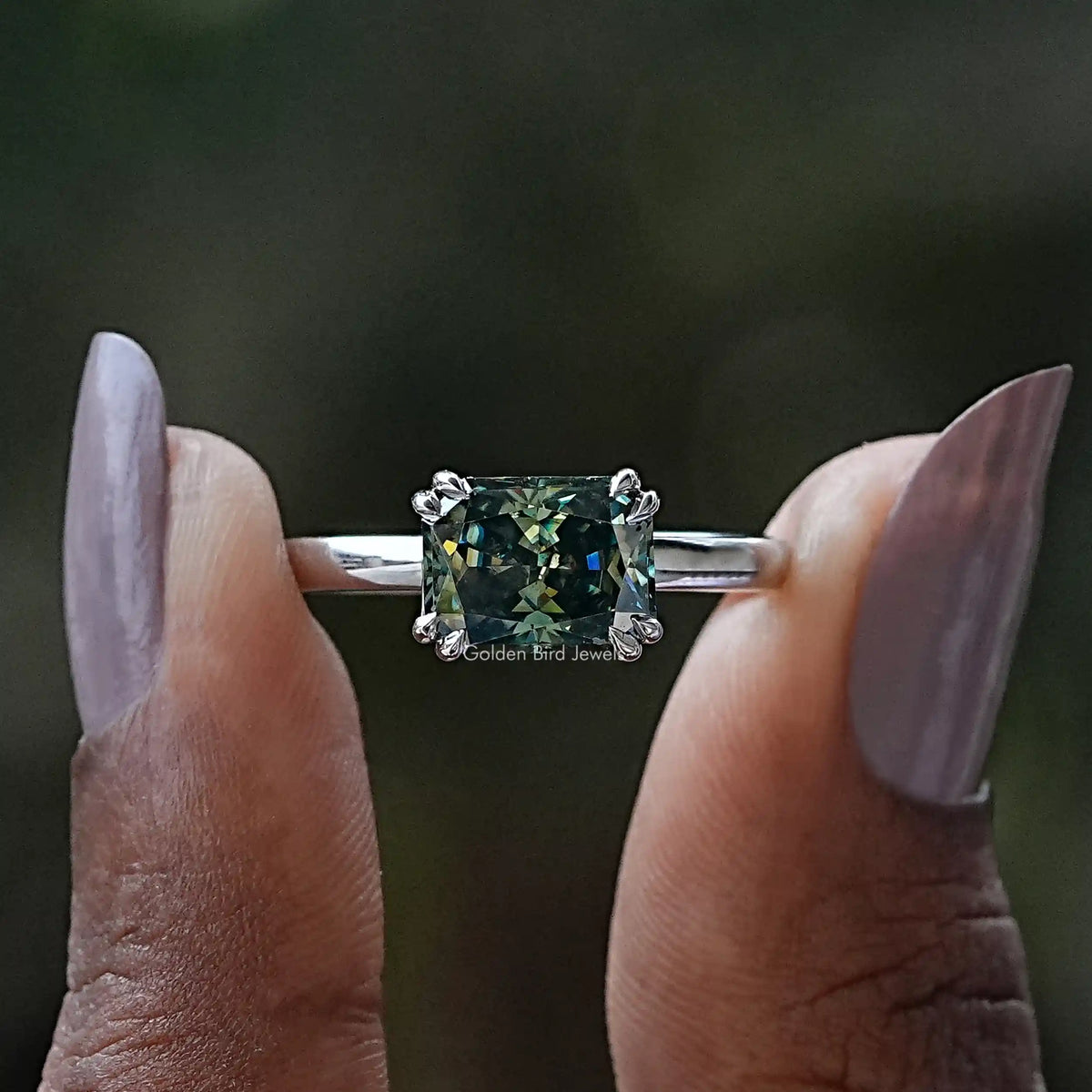 Two fingers holding the Radiant Cut Moissanite Solitaire Engagement Ring