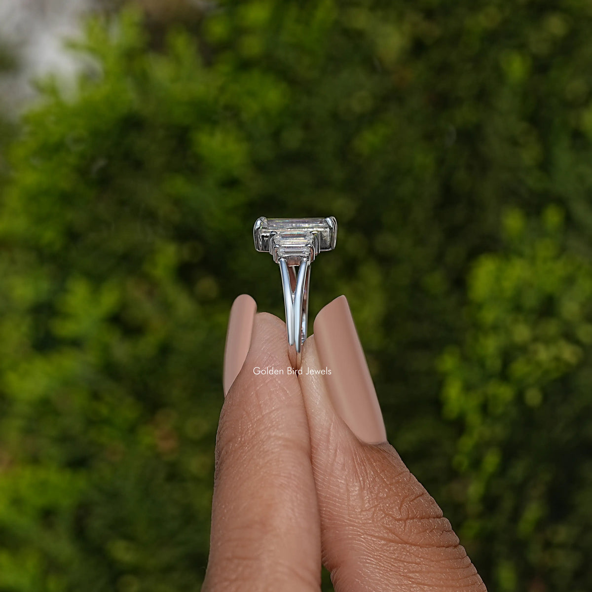 Split shank ring showing centered emerald-cut stone setting, silver tone