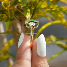 Side View of Three Stone Emerald Cut Moissanite Ring In two fingers