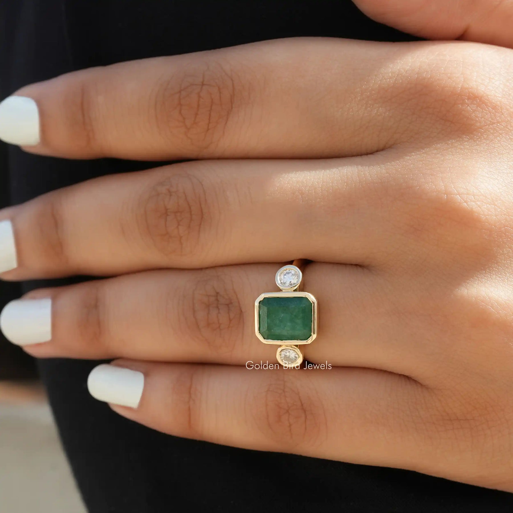 [In finger front view of emerald and round cut moissanite ring made of yellow gold]-[Golden Bird  Jewels]
