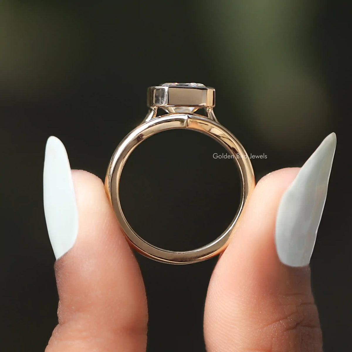 Back View of Moissanite Solitaire Bezel Set Ring In two fingers
