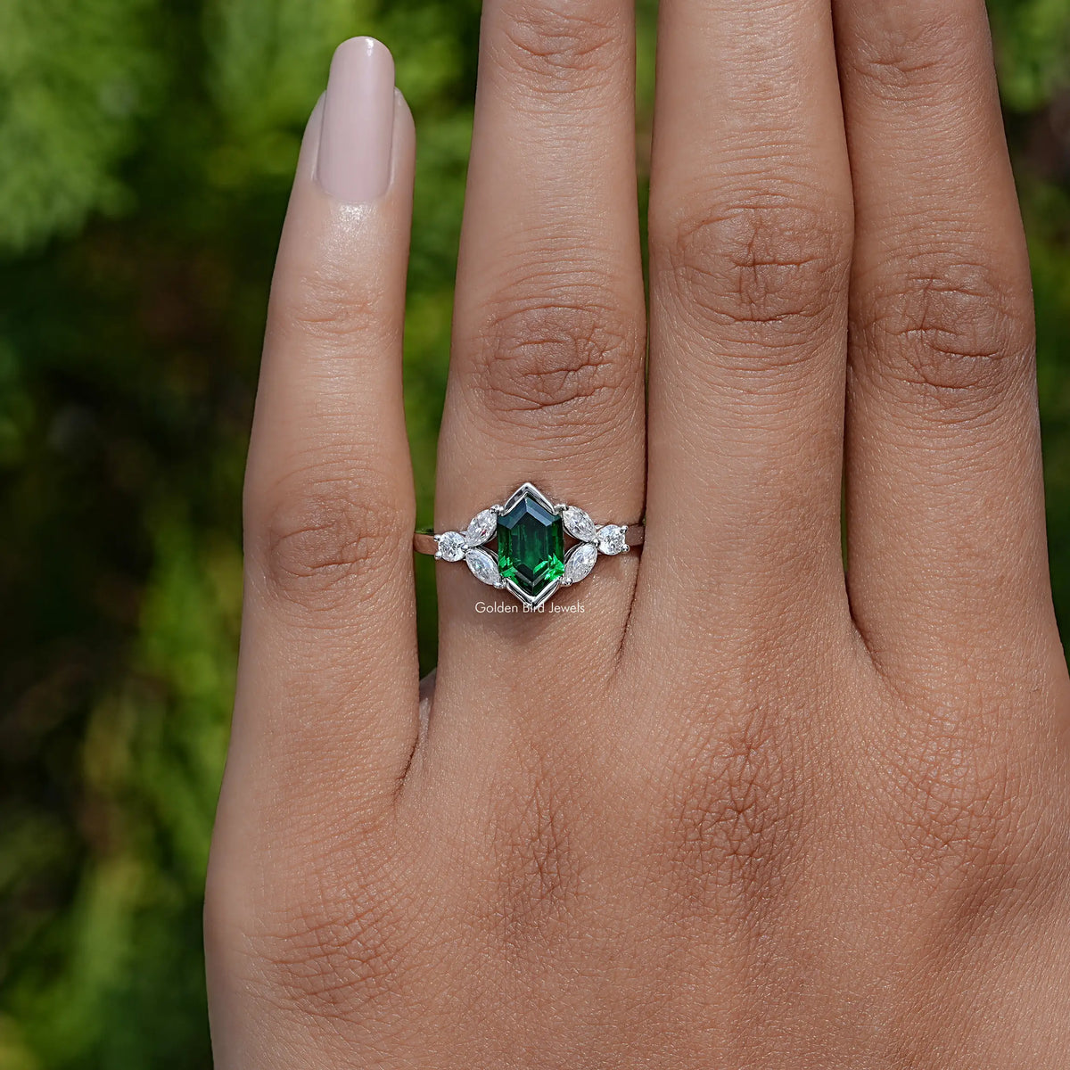 Emerald green hexagon-cut gemstone ring with marquise and round white moissanite accents