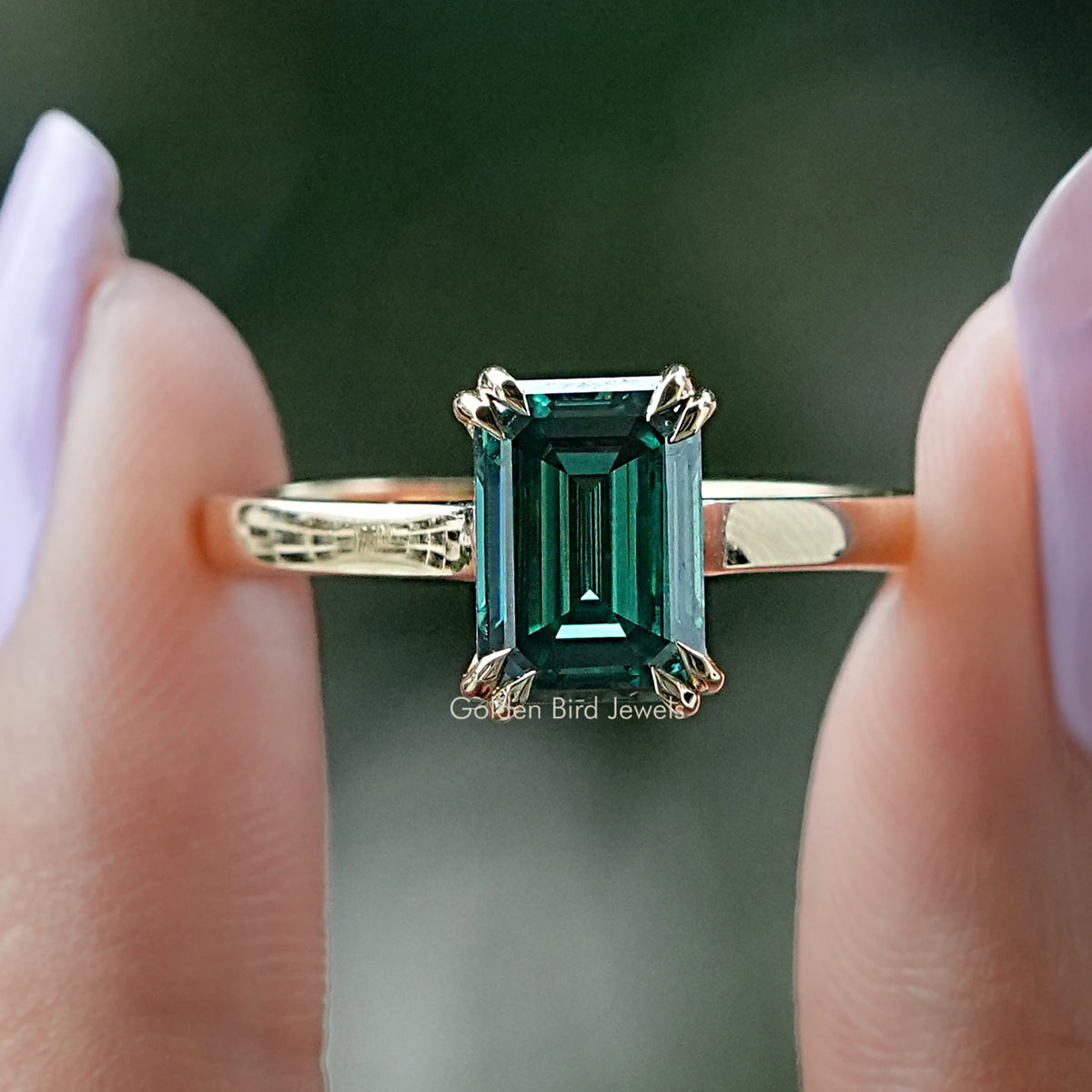 Green emerald-cut moissanite solitaire ring with a simple polished band