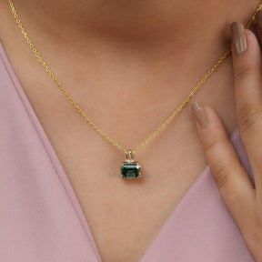 [In neck front view of moissanite emerald cut pendant in 14k yellow gold]-[Golden Bird Jewels]