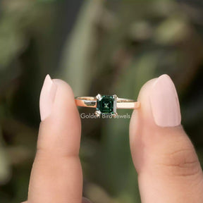 Two fingers holding the Green Asscher Cut Solitaire Moissanite Ring