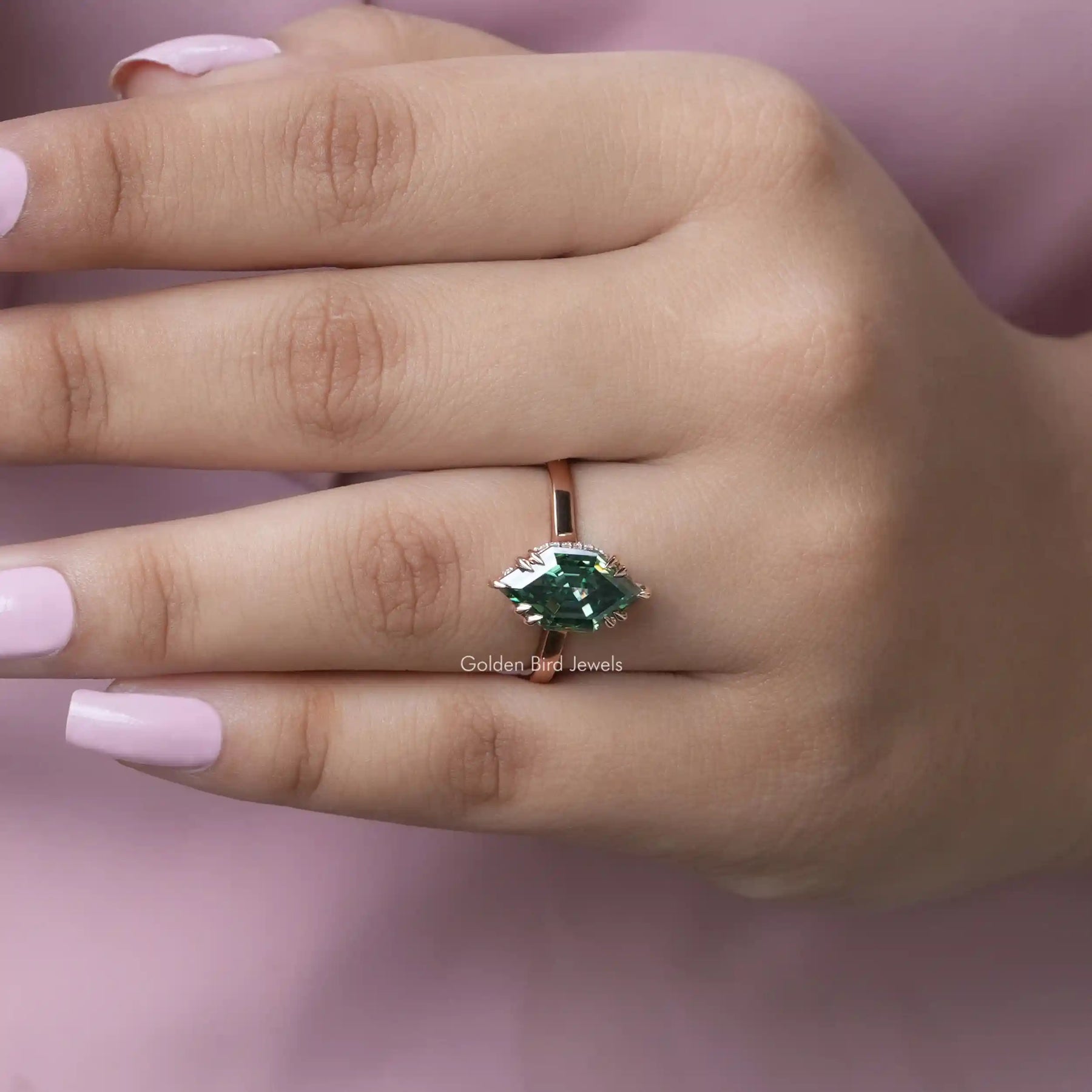 [In hand front view of green marquise cut solitaire ring in 14k yellow gold]-[Golden Bird Jewels]