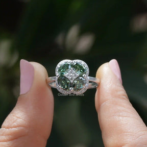 [In two finger front view of green oval cut halo moissanite ring in white gold]-[Golden Bird Jewels]
