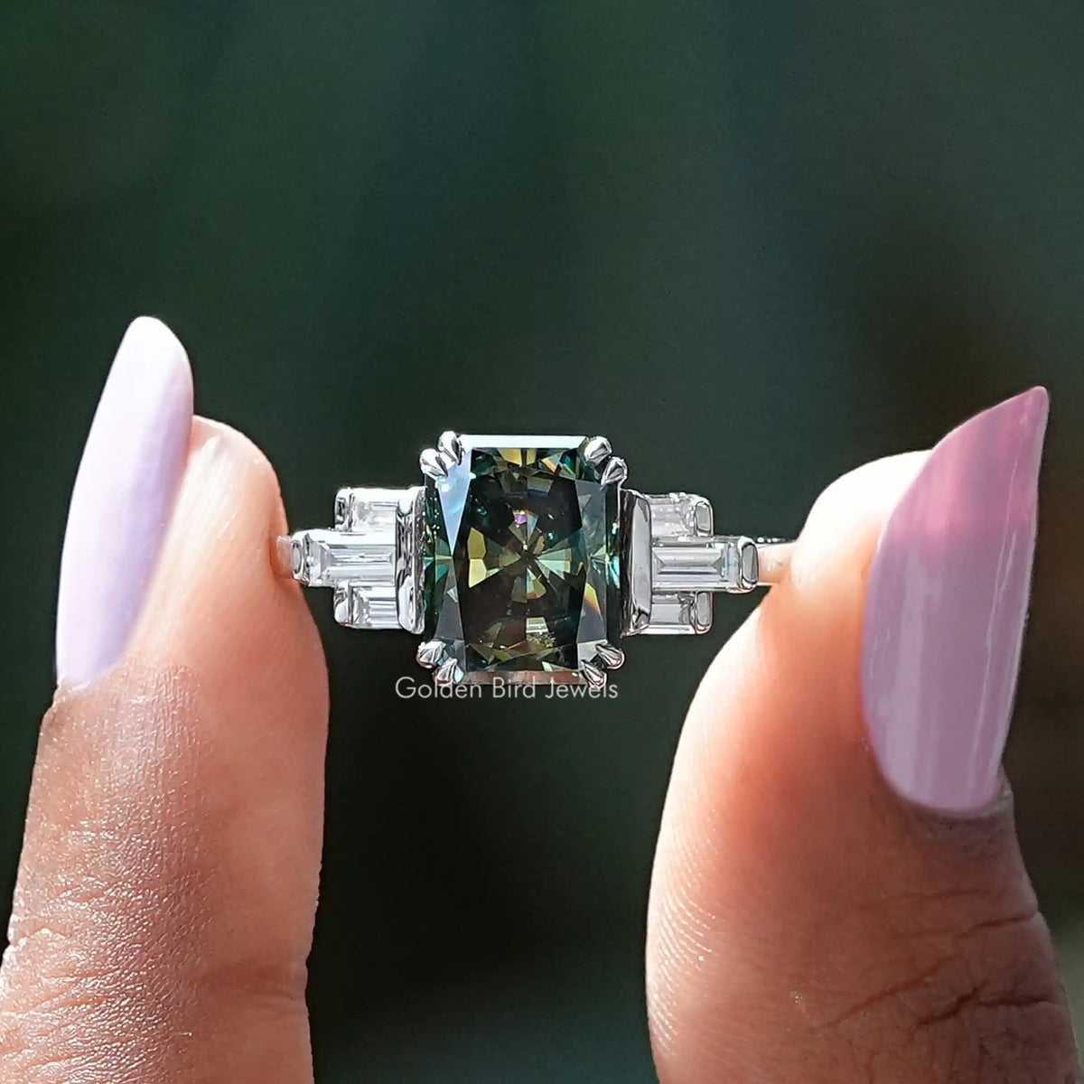 Two fingers holding the Radiant Cut Moissanite Engagement Ring