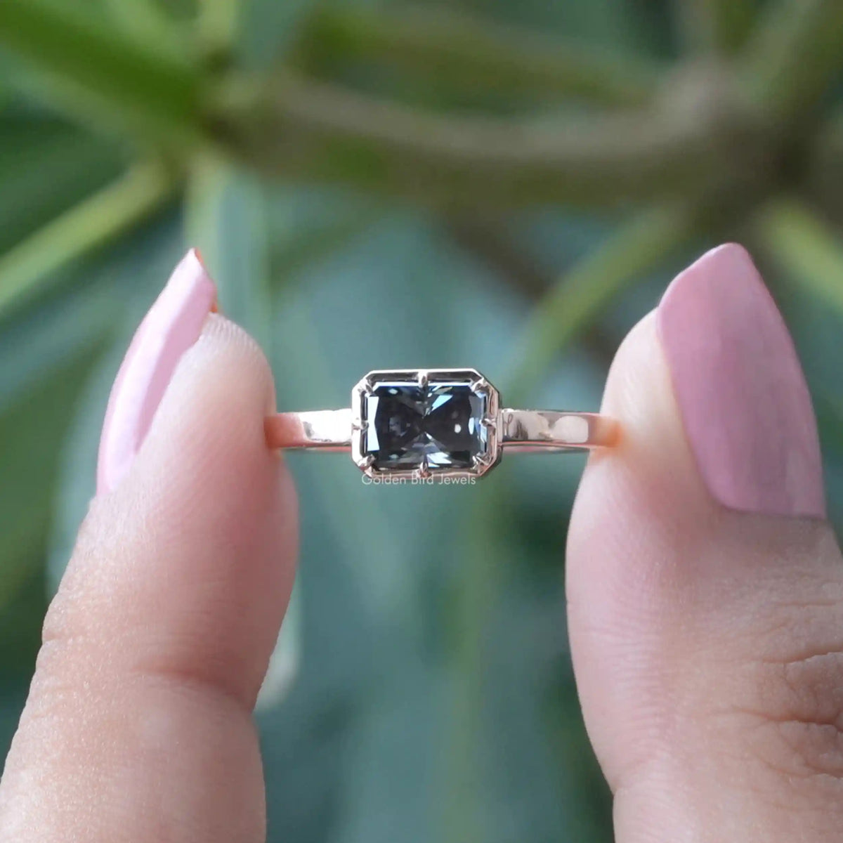 [In two finger front view of radiant cut moissanite solitaire ring]-[Golden Bird Jewels]