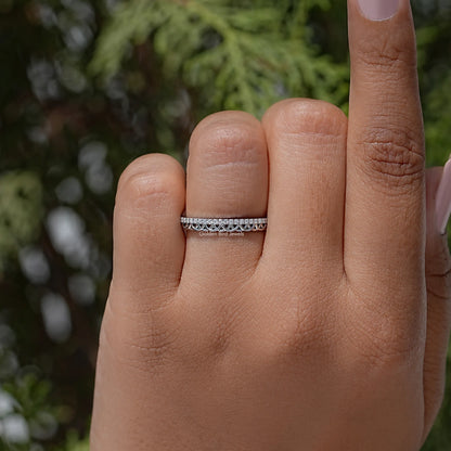 Silver stacking ring band with clear stones, centered on finger