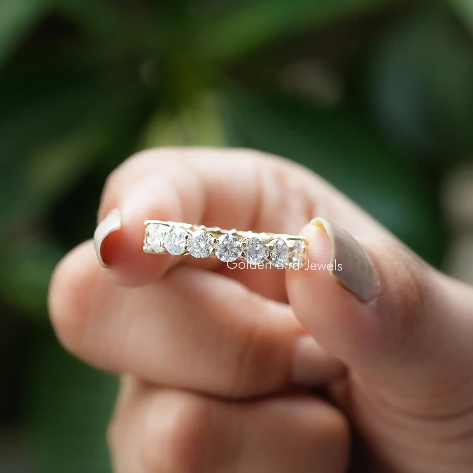 [In two finger front view of emerald cut and round cut moissanite wedding band]-[Golden Bird Jewels]