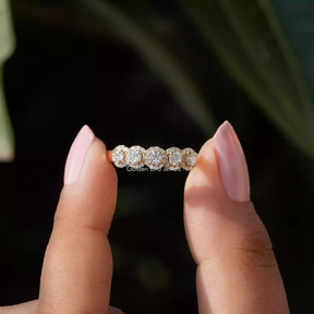 Two fingers holding the Moissanite Round Cut Wedding Band