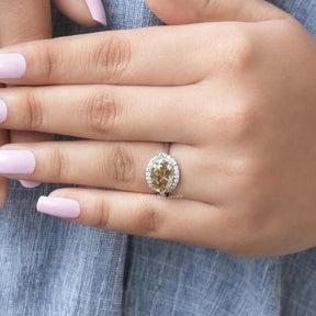 [In finger front view of brown oval cut halo style moissanite ring in 14k white gold]-[Golden Bird Jewels]