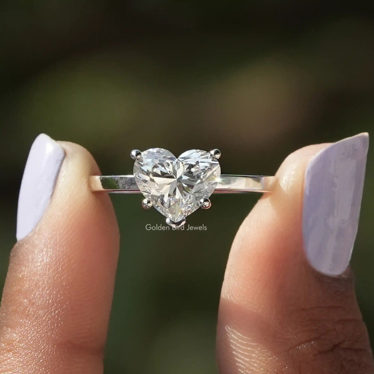 Two fingers holding the Heart Cut Lab Diamond Engagement Ring