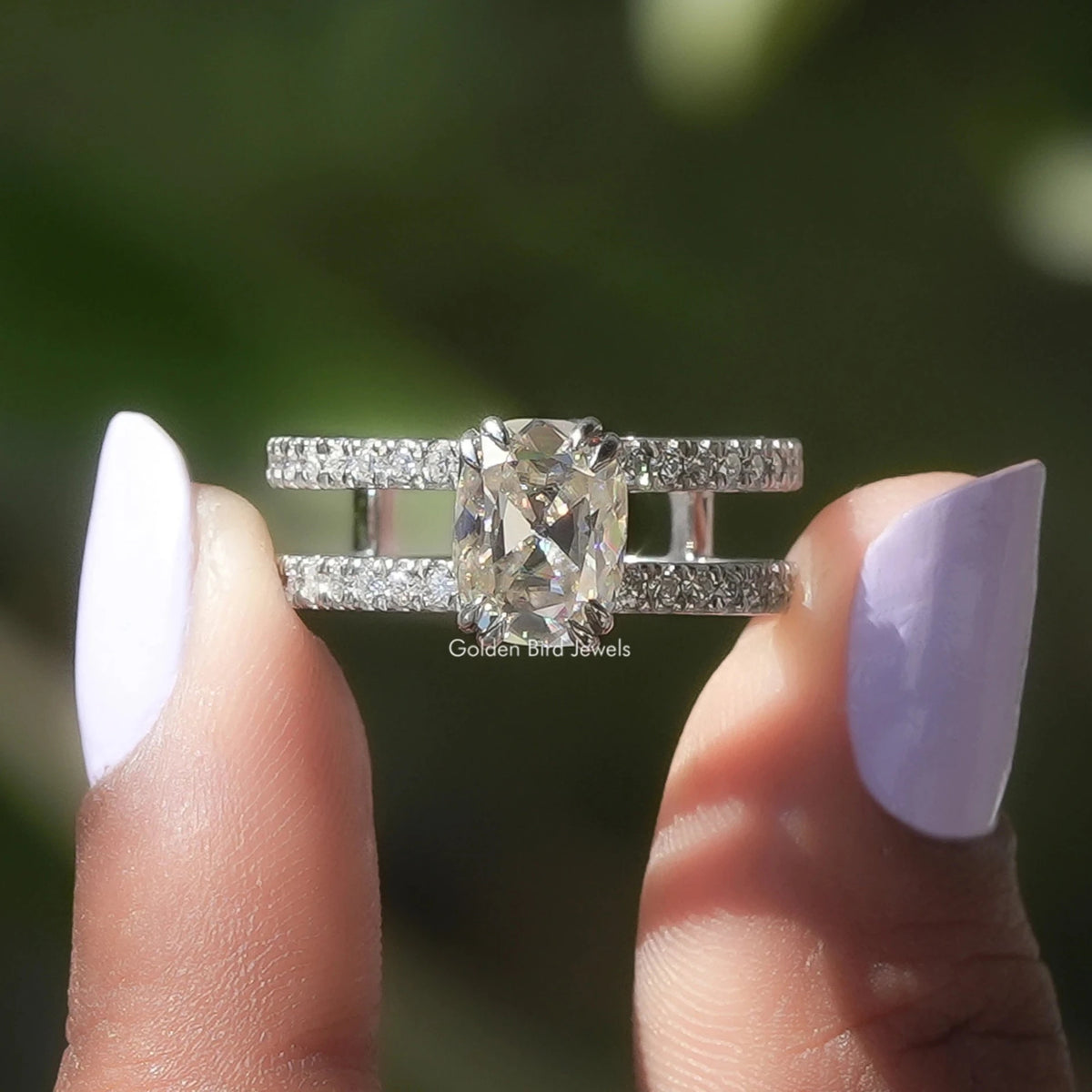 Two fingers holding the Old Mine Cushion Cut Moissanite Engagement Ring