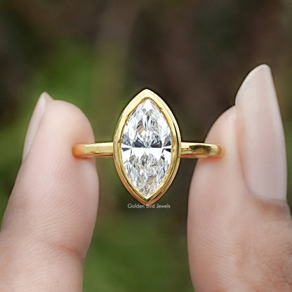 Marquise Cut Lab Diamond Bezel Set Ring Between Two Fingers