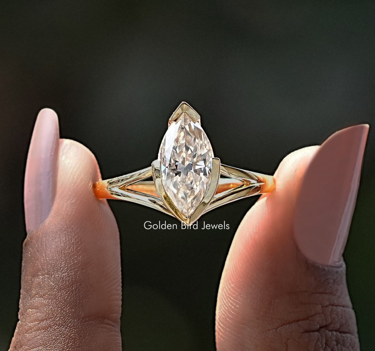 Two fingers holding the Moissanite Marquise Cut Split Shank Ring
