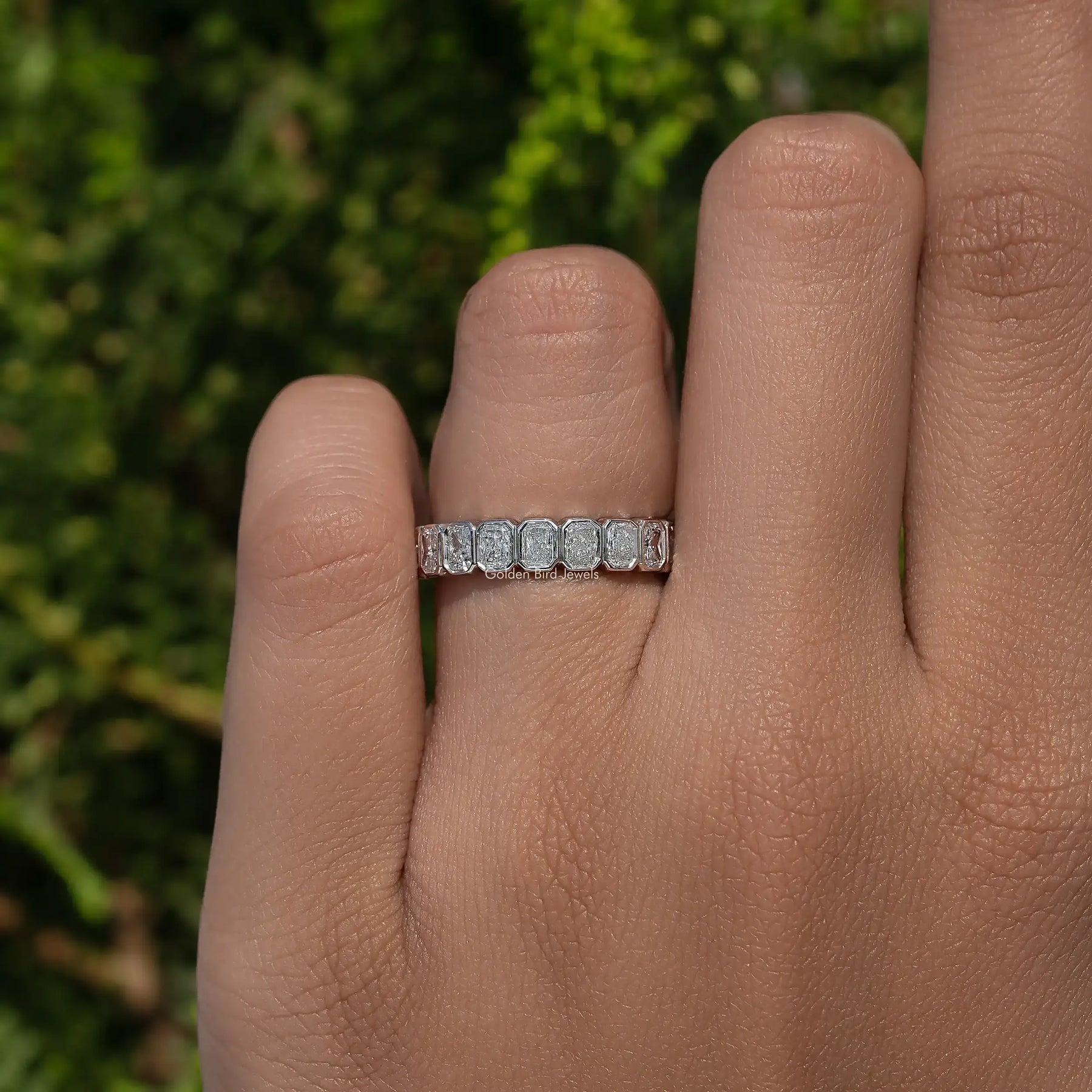 In finger view of Bezel Set Radiant Cut Full Eternity Band