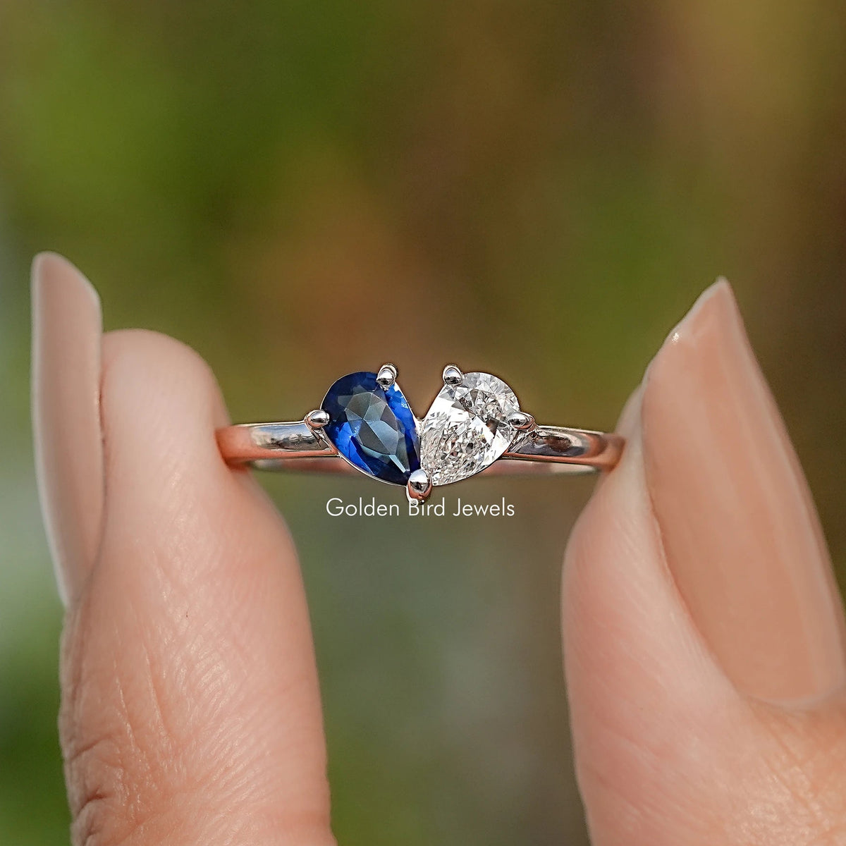 Sterling silver toi et moi ring featuring a blue pear stone and a heart-shaped white stone