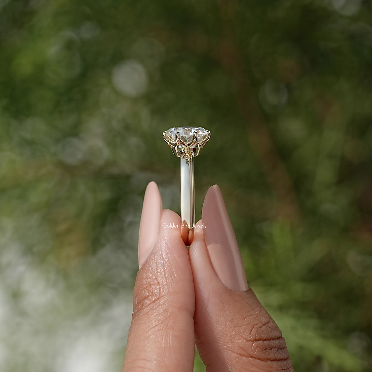 Moissanite solitaire ring shown from side, prong-set round center stone