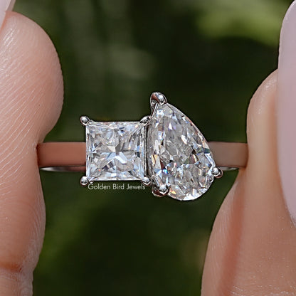 Toi et moi moissanite ring with pear and princess cut stones on a silver band