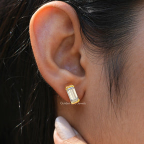 This bezel set moissanite earrings in an emerald cut moissanite