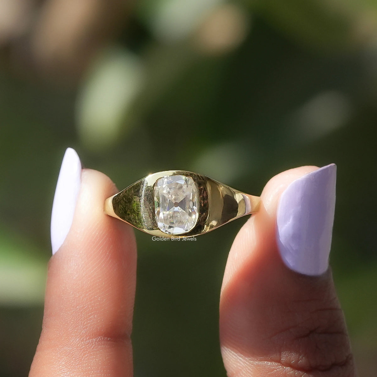 Two fingers holding the Elongated Old Mine Cushion Ring