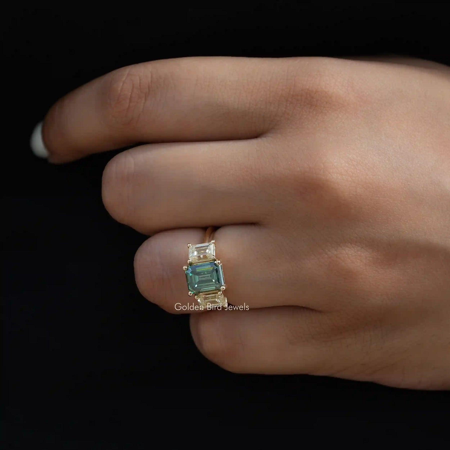 [In finger side view of emerald cut moissanite 3 stone ring]-[Golden Bird Jewels]