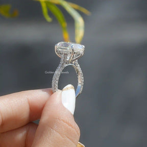 Side View of Hidden Halo Oval Cut Engagement Ring In two fingers
