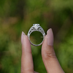 OEC round Moissanite Art  ring  holding in two fingers 