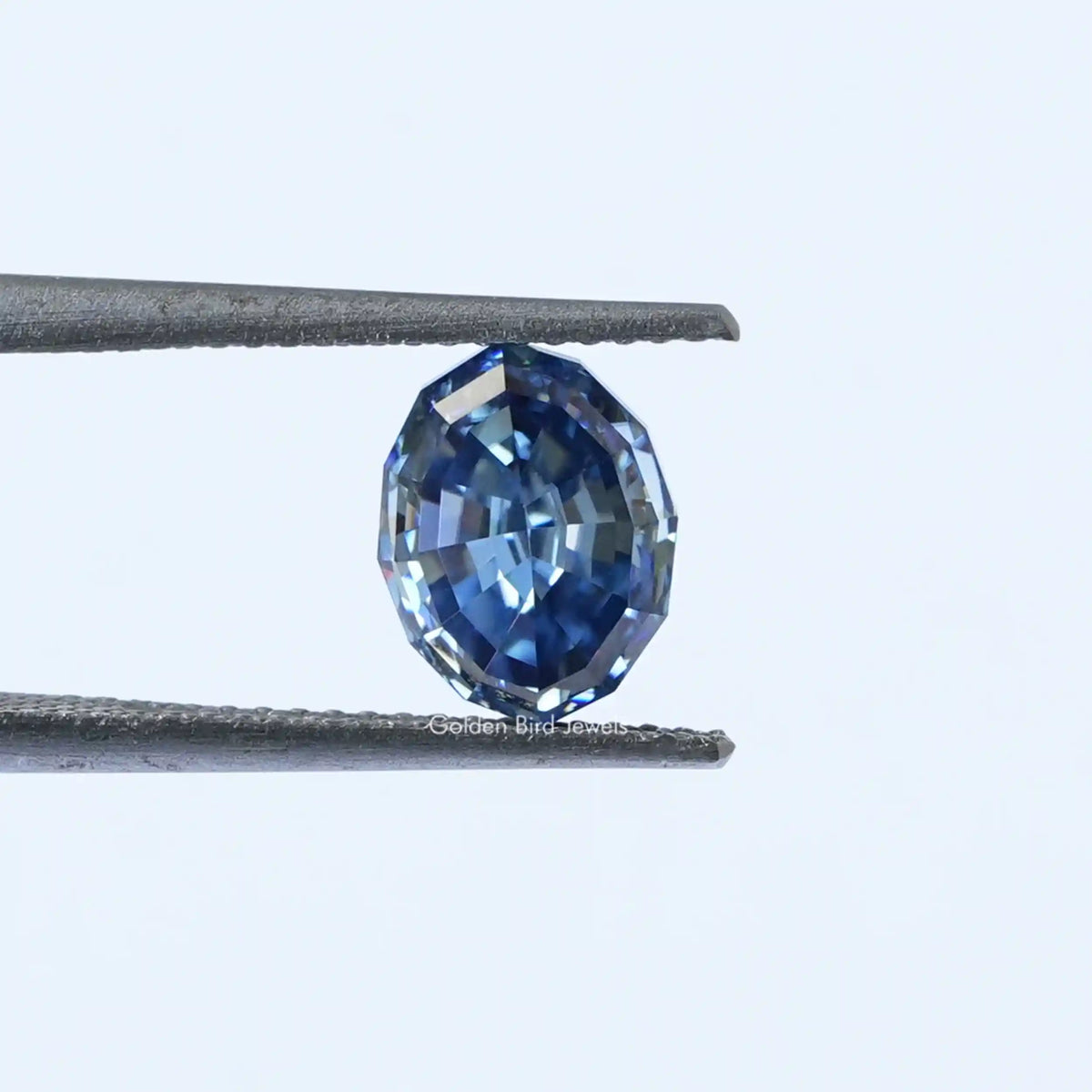 [In tweezer front view of oval cut loose moissanite]-[Golden Bird Jewels]