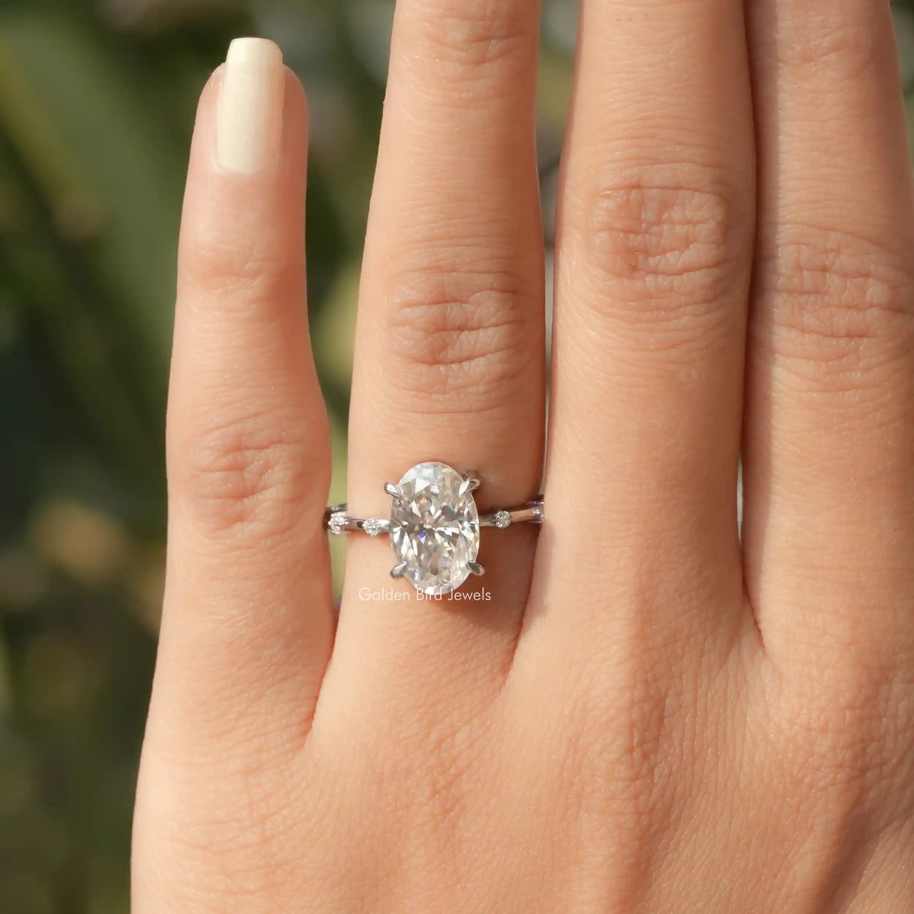 [In finger front view of oval moissanite engagement ring made of 14k white gold]-[Golden Bird Jewels]