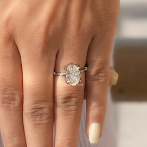 [In finger front view of moissanite oval cut accent stone ring set in 4 prong setting]-[Golden Bird Jewels]