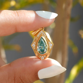 [In two finger front view of blue pear cut moissanite pendant]-[Golden Bird Jewels]