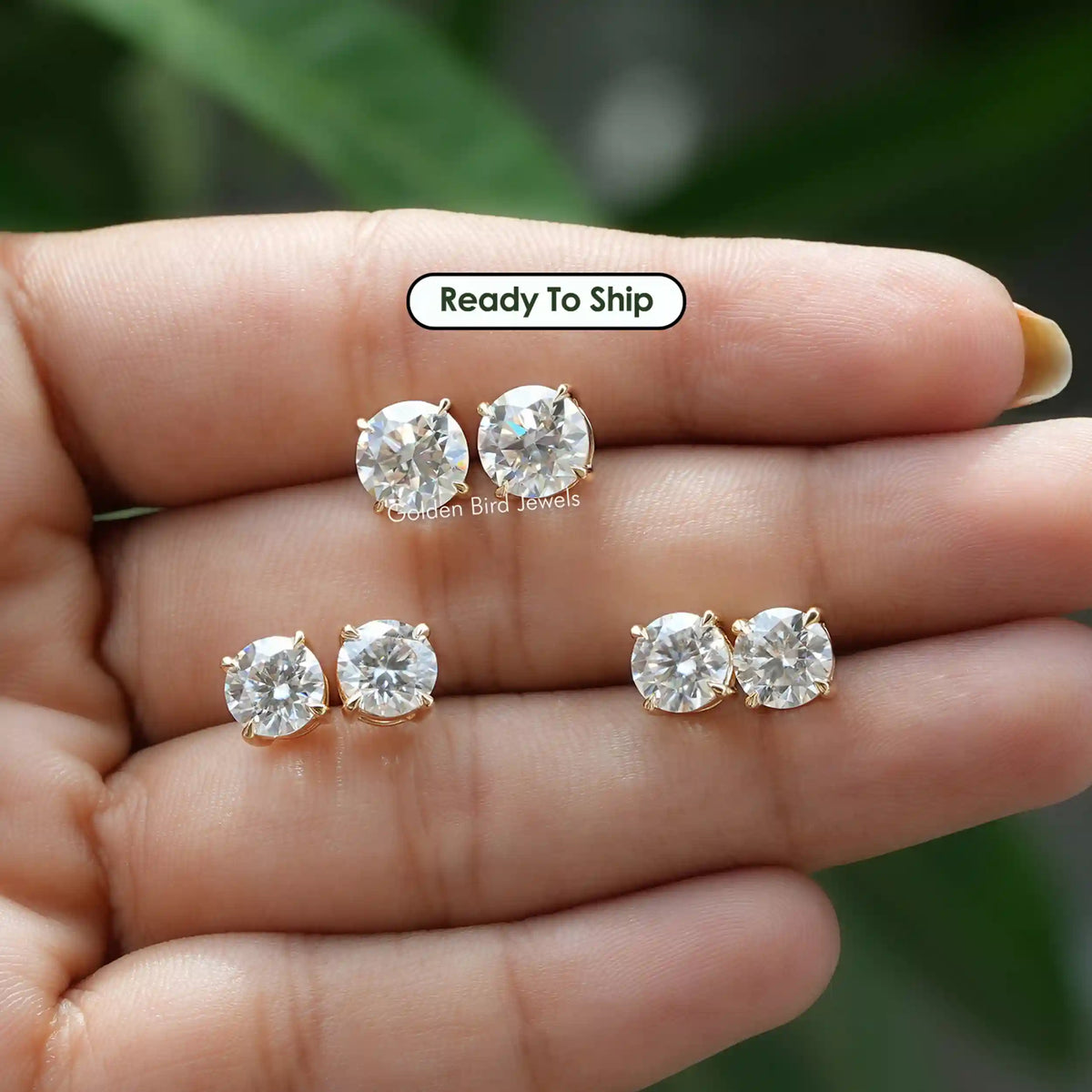 In a finger view of a multi-carat moissanite stud earrings 