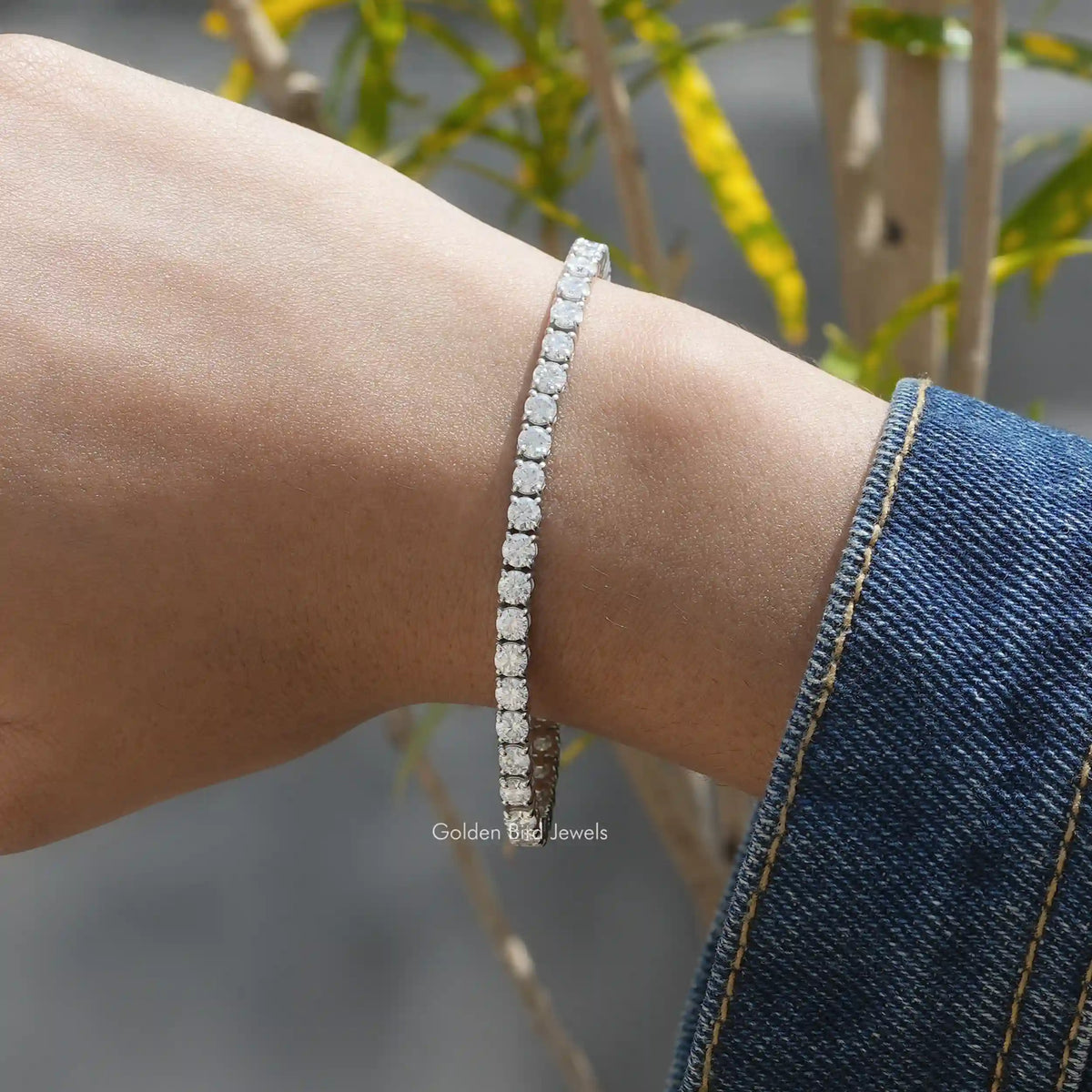 In hand front view of moissanite round cut tennis bracelet