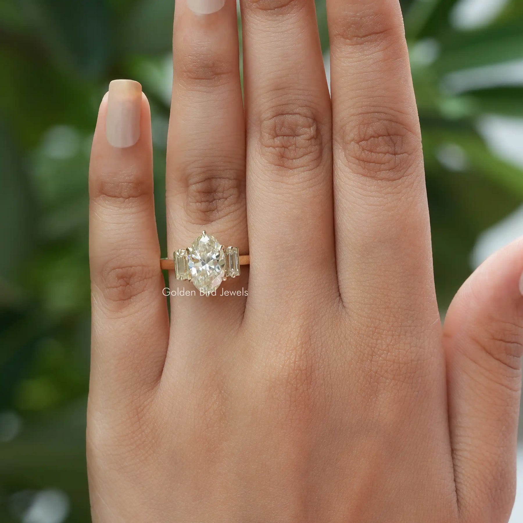 [In Finger Front View Of 3-Stone Moissanite Engagement Ring Made Of Moval Cut Stone]-[Golden Bird Jewels]