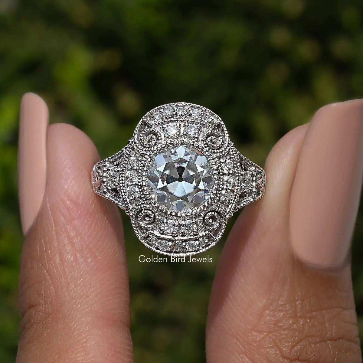 Sterling silver round moissanite ring with detailed filigree halo and swirl accents