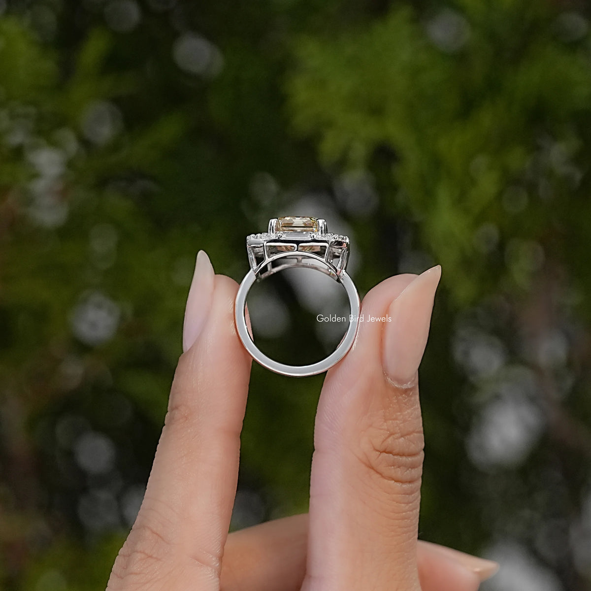 Sterling silver halo ring shown from the side, with a raised rectangular center stone and open band